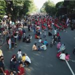 (beritadaerah - Kota Surakarta) Komitmen Pemerintah Kota Surakarta dalam menggerakkan roda perekonomian masyarakat telah mengambil langkah progresif pada acara Car Free Day (CFD) di Solo. Minggu lalu, sekitar 400 pedagang kaki lima (PKL) mulai mengisi zona 1 hingga zona 4, mencakup area dari Gladak hingga simpang Ngapeman, membuktikan langkah positif dalam mendukung UMKM lokal. Ruang bagi sekitar 100 pedagang masih tersedia di zona tersebut. Kapasitas untuk menampung sekitar 500 pedagang telah disediakan oleh Pemkot Solo, sementara ruang yang tersisa diharapkan dapat diisi oleh pedagang lama yang belum aktif kembali berjualan. Pemkot Solo akan mengevaluasi kehadiran pedagang lama yang belum aktif hingga pekan depan. Jika masih tersedia ruang, Pemkot Solo akan membuka kesempatan bagi pedagang baru. Meskipun pembukaan zona baru untuk berjualan belum sepenuhnya mengubah tingkat keramaian, relokasi sejumlah event dari simpang empat Ngapeman ke zona 1-4 diharapkan dapat menghidupkan suasana. Dishub Solo berencana untuk memindahkan acara yang ada di lokasi sebelumnya ke area yang baru. Pemindahan ini dilakukan untuk menghidupkan zona 1-4. Jika zona ini ramai, PKL akan semakin aktif. Selain pengalihan lokasi event, Pemkot Solo juga akan meningkatkan pengawasan dengan menempatkan satu petugas Linmas setiap radius 75 hingga 100 meter. Mereka akan bekerja sama dengan Satpol PP Kota Solo dalam menegakkan aturan yang berlaku. Pemerintah Kota Surakarta menegaskan komitmennya untuk mendukung ekonomi masyarakat melalui acara CFD. Langkah ini mencakup perluasan lokasi berjualan PKL sebagai upaya agar perekonomian menjadi lebih merata. Dengan perluasan lokasi berjualan, diharapkan roda perekonomian tidak hanya berputar di tempat tertentu, melainkan juga merata di berbagai wilayah. Ini akan memberi dampak positif secara menyeluruh bagi masyarakat. Pemkot Solo telah berkoordinasi dengan berbagai instansi terkait untuk menjamin kelancaran acara CFD. Penempatan Linmas di wilayah-wilayah terpilih juga merupakan bagian dari upaya untuk memastikan keteraturan pedagang serta kebersihan area tersebut. Masih terdapat ruang yang kosong dan Pemkot Solo berupaya untuk memanfaatkannya, terutama bagi pedagang lama yang pernah berjualan di CFD. Namun, koordinasi dengan berbagai pihak sangat diperlukan agar kegiatan ini berjalan dengan baik. Dengan upaya ini, harapannya adalah perubahan positif pada CFD Solo akan terus memberikan dorongan ekonomi yang merata bagi masyarakat, sambil tetap memperhatikan keteraturan dan kebersihan area berjualan. Semoga langkah-langkah ini membawa manfaat yang nyata bagi UMKM lokal serta meningkatkan kualitas acara CFD bagi seluruh warga Solo.